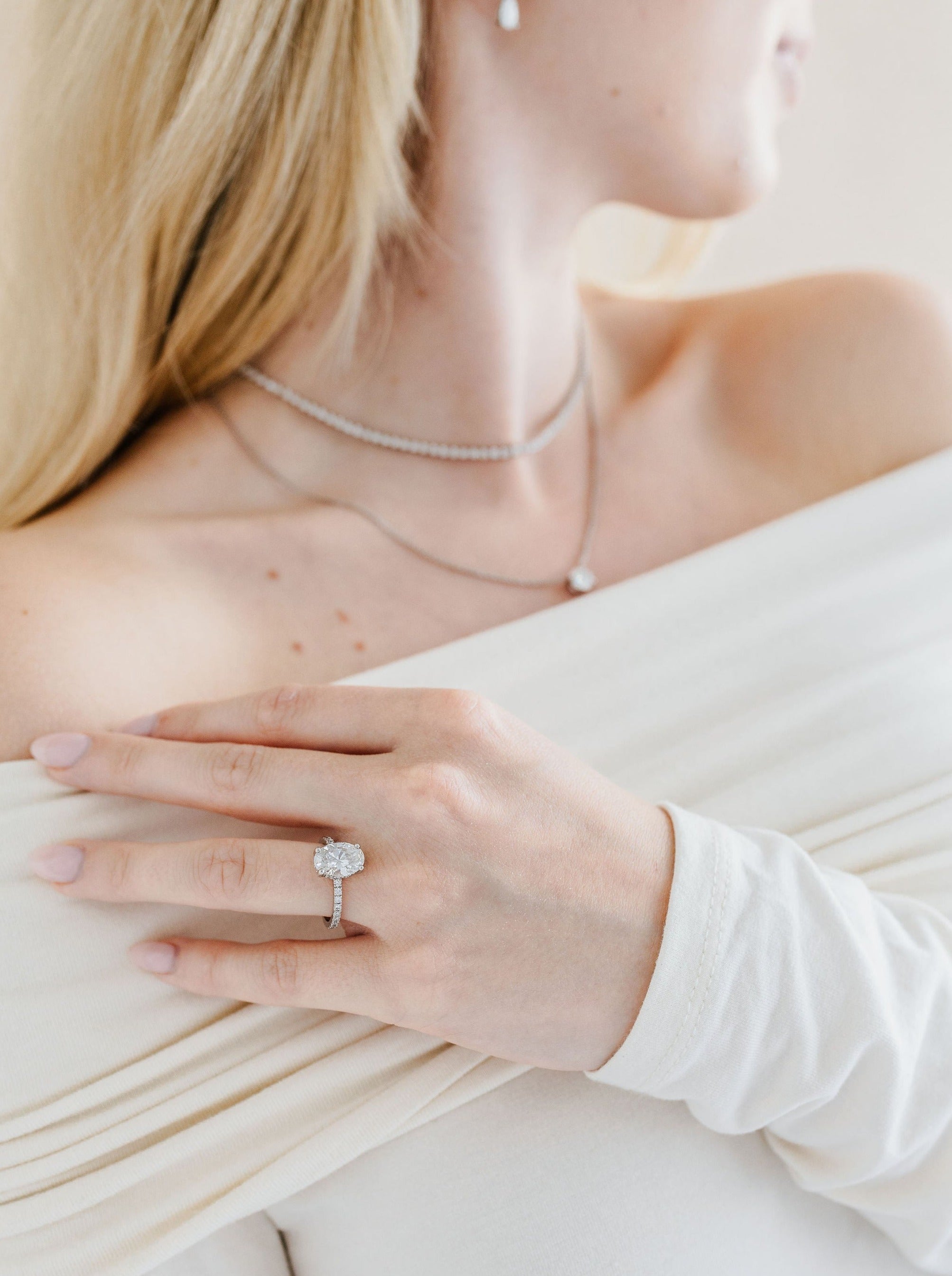 Ovaali solitaire kihlasormus sivukivillä - platinaa